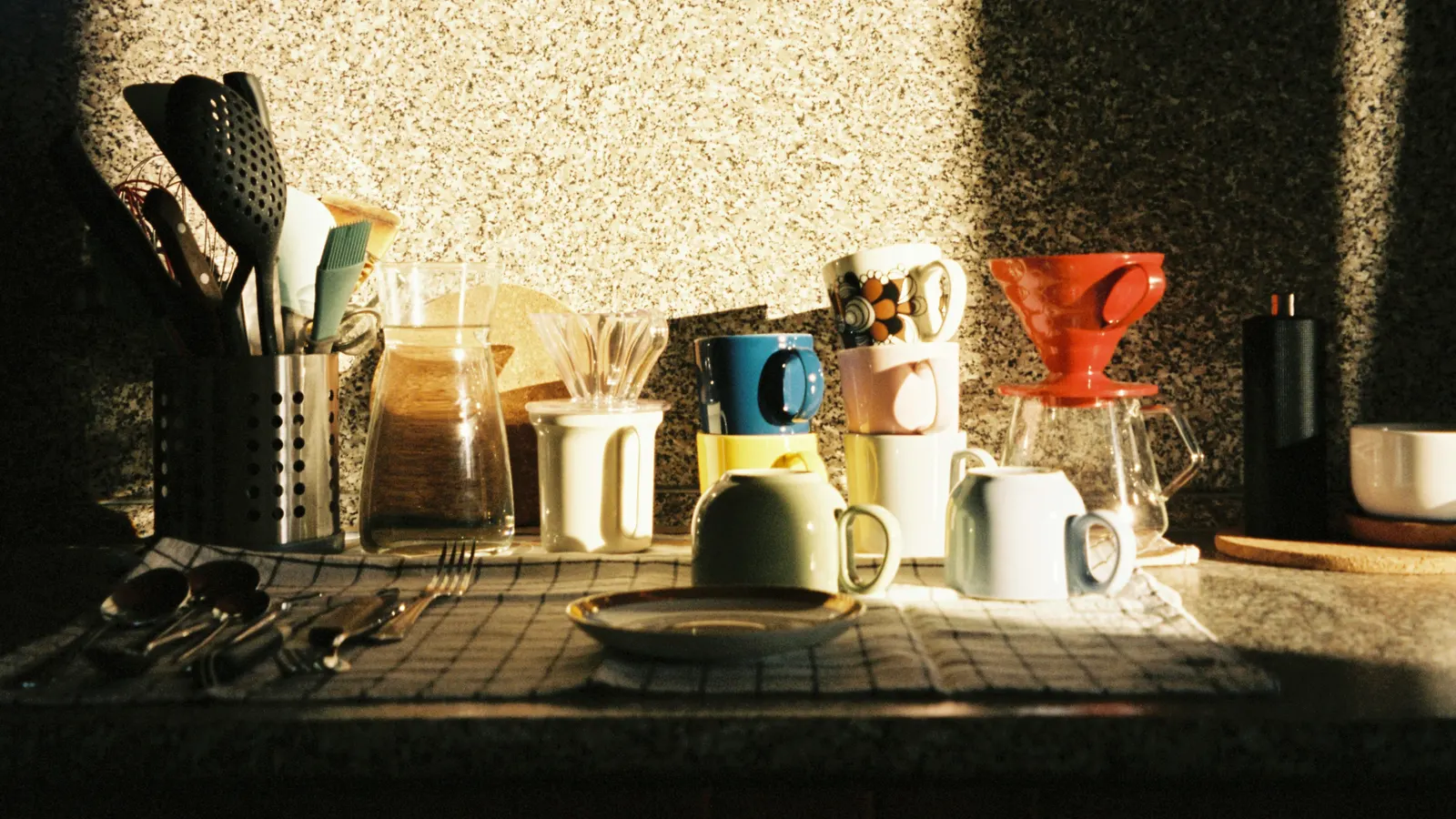 Empty kitchen at golden hour — coffee mugs catching the morning light