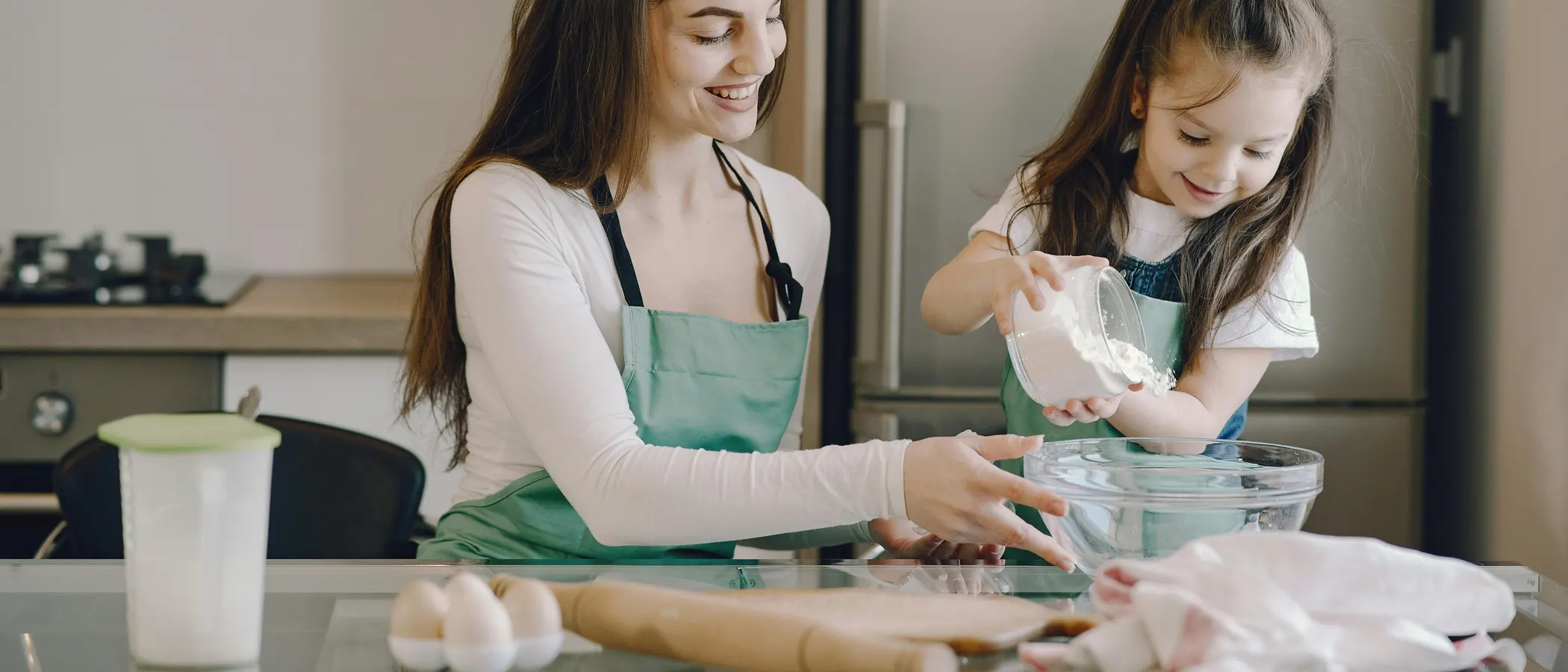 A parent and child cooking together at home