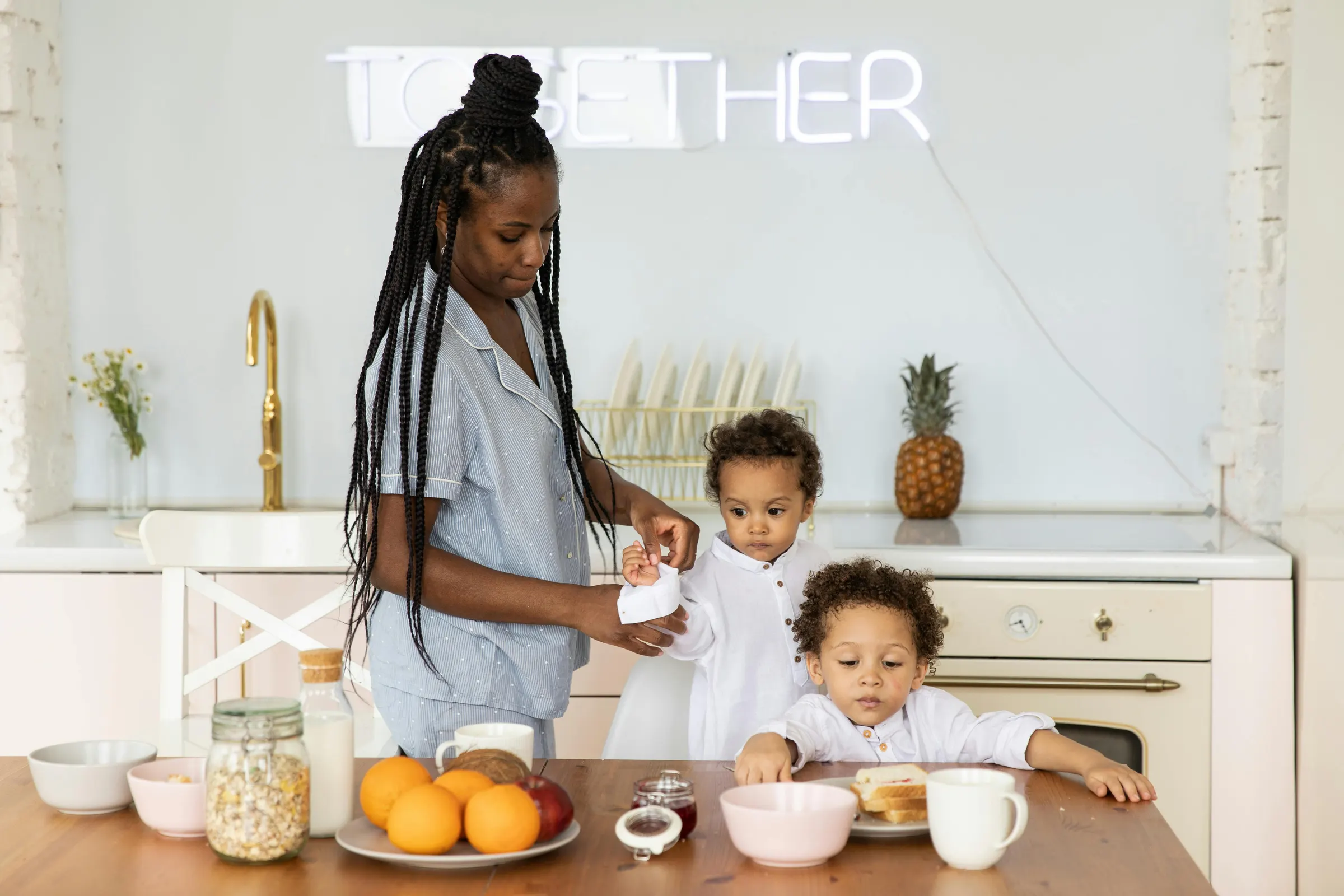 A parent and two children at the kitchen table together